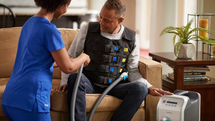 Nurse helping patient put on the respirtech vest